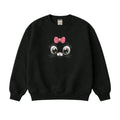 Black sweatshirt with a cartoon face design featuring a pink bow on a white background