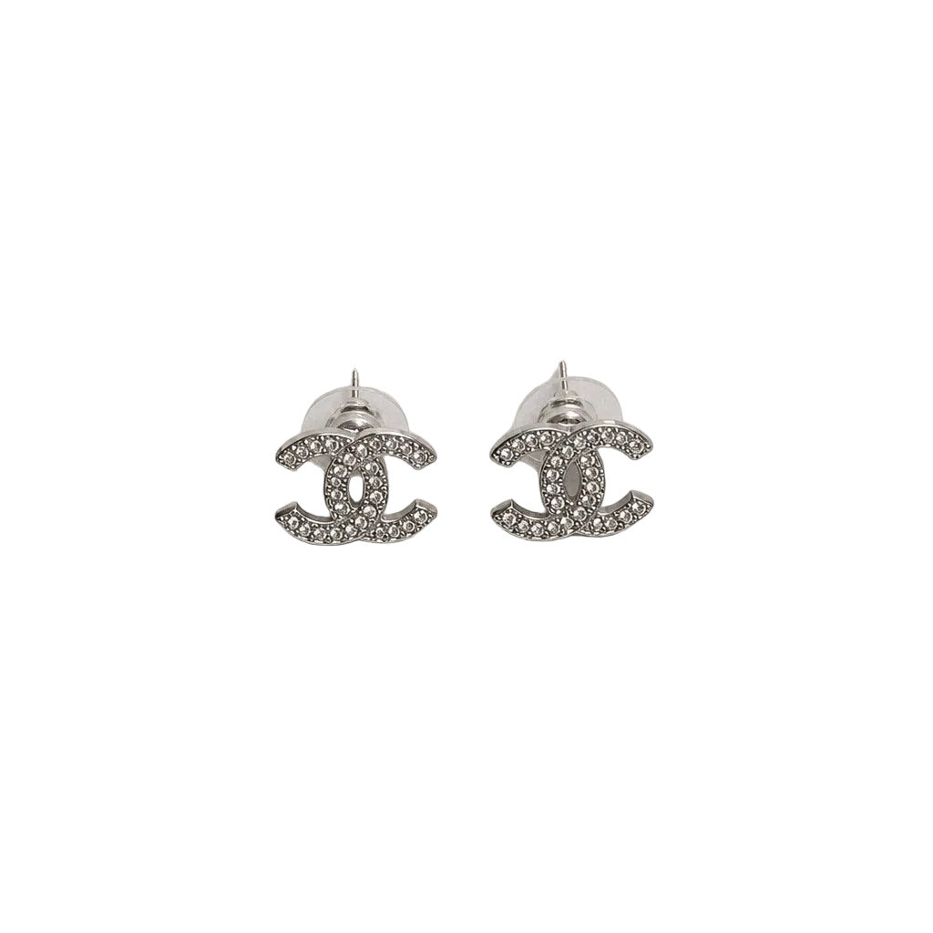 Silver Chanel earrings on a light gray background
