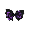 Black glittery bow with purple center on a light gray background