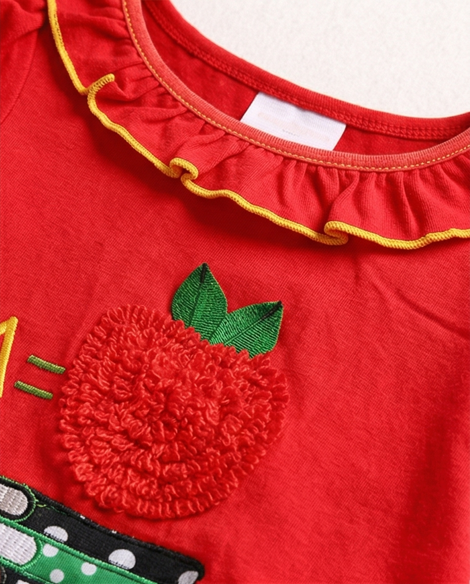 Red shirt with a textured apple design and green leaves on a white background