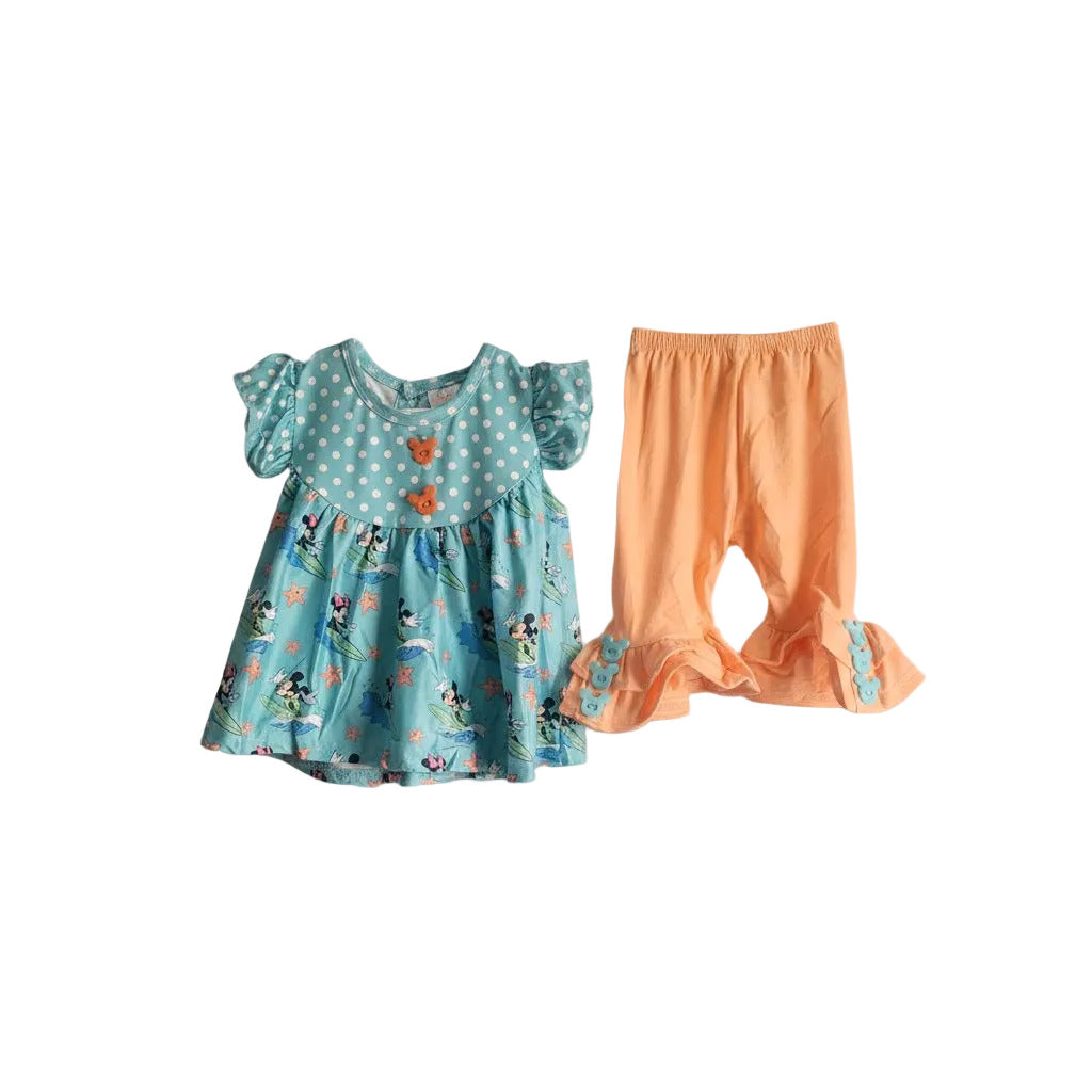 Children's outfit with a blue dress with cartoon character print and orange pants on a light gray background