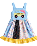 Children's dress with school bus design and colorful patterned skirt on a white background