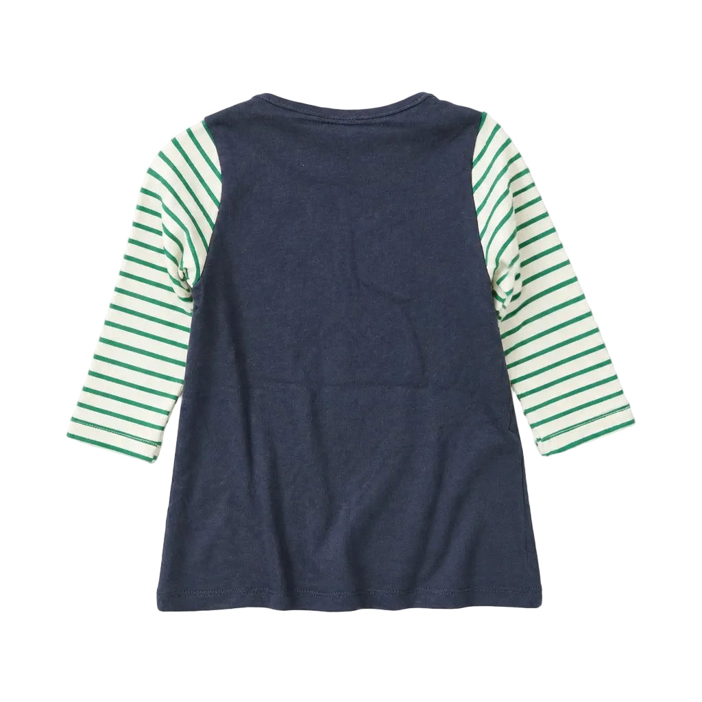 A children's long-sleeve top shown from the back, featuring a solid navy blue body and green-and-white striped sleeves, laid flat on a light gray background.