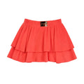 Coral layered skirt with a brand label on a light gray background