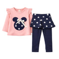 A toddler girl's two-piece outfit set featuring a light pink long-sleeve top with a navy blue mouse-head applique and white bow, paired with navy blue leggings and matching navy polka-dot ruffled shorts.