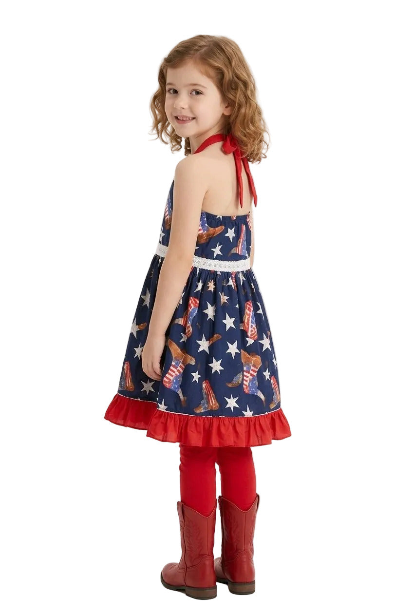 Young girl wearing a patriotic dress with boots and stars, standing against a white background