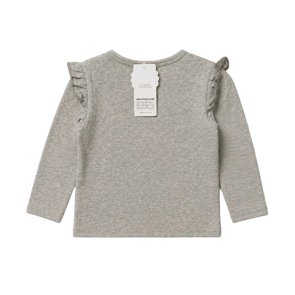 A light gray heather long-sleeve baby top with ruffled shoulder details and a white paper tag attached to the back neckline, shown against a neutral light gray background.