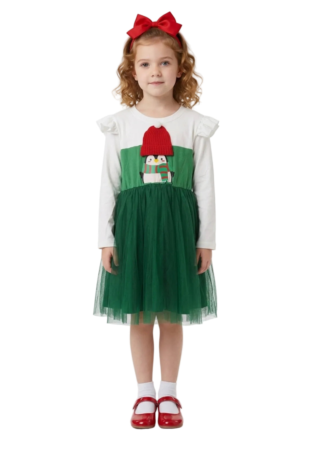 Young girl wearing a green and red dress with a white top, standing against a white background.