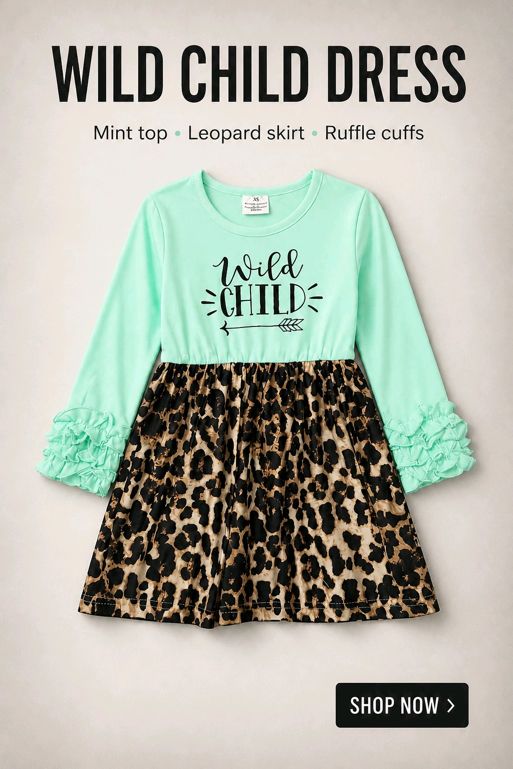 A children's dress with a mint green long-sleeve top featuring a black 'Wild Child' graphic, paired with a leopard-print skirt and ruffled cuffs, shown on a light beige background with promotional text.