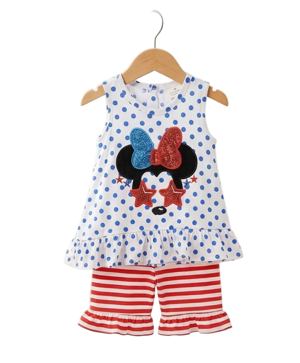Children's outfit with polka dot top and red shorts on a hanger against a white background.
