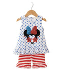 Children's outfit with polka dot top and red shorts on a hanger against a white background.