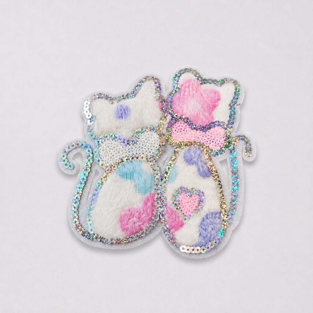 Decorative cat-shaped patch with sequins and pastel colors on a light gray background